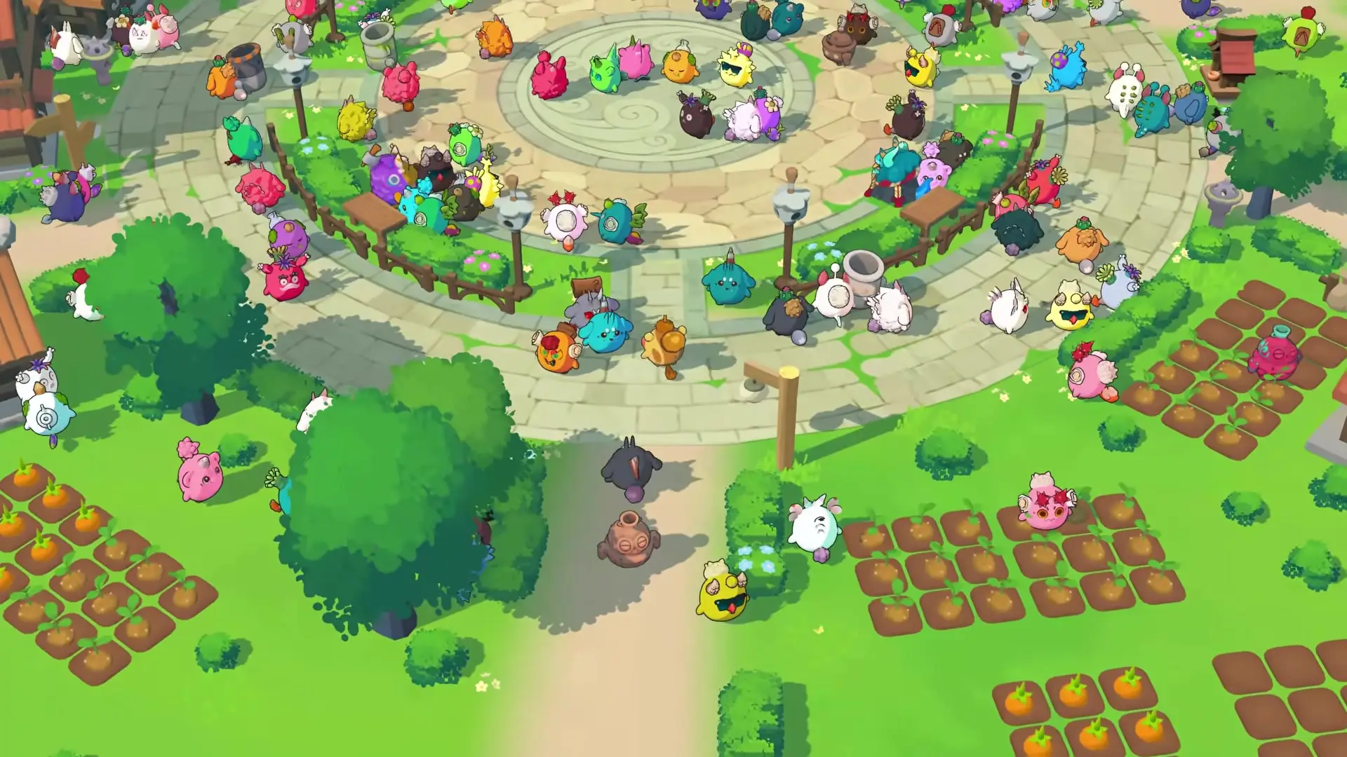 In the game Axie Infinity, various colorful and diverse creatures are gathered around a circular plaza in a garden-like setting, some of them with plants growing nearby.