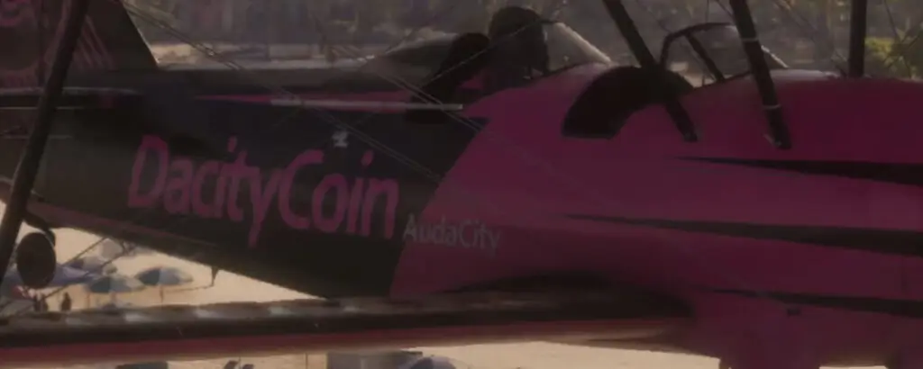 a close crop of the logo on the plane at 0:56. Alt text: The "DacityCoin" and "AudaCity" logo on the plane in the GTA VI launch trailer.
